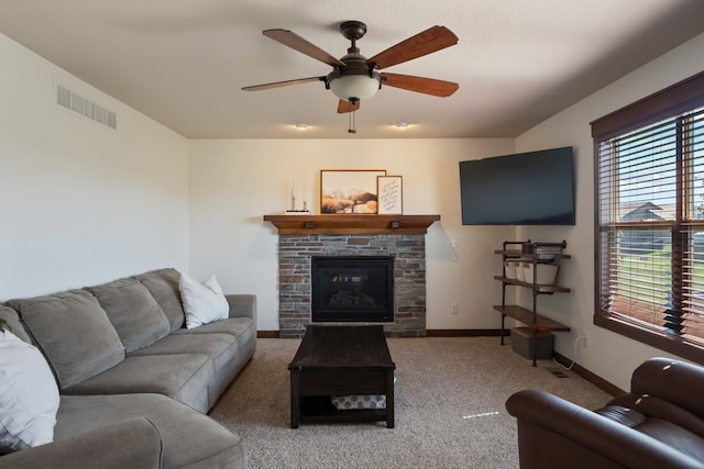 carpeted living room with ceiling fan and a fireplace