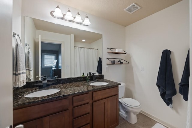 bathroom with toilet, visible vents, a sink, and tile patterned floors