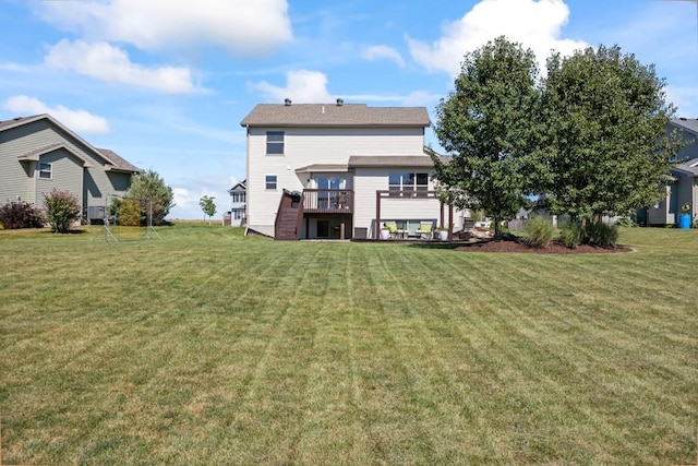 rear view of house with a lawn and a deck