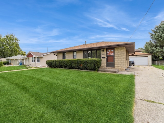 single story home with an outbuilding, a garage, and a front lawn