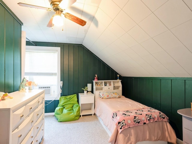 bedroom with light colored carpet, lofted ceiling, ceiling fan, cooling unit, and wood walls