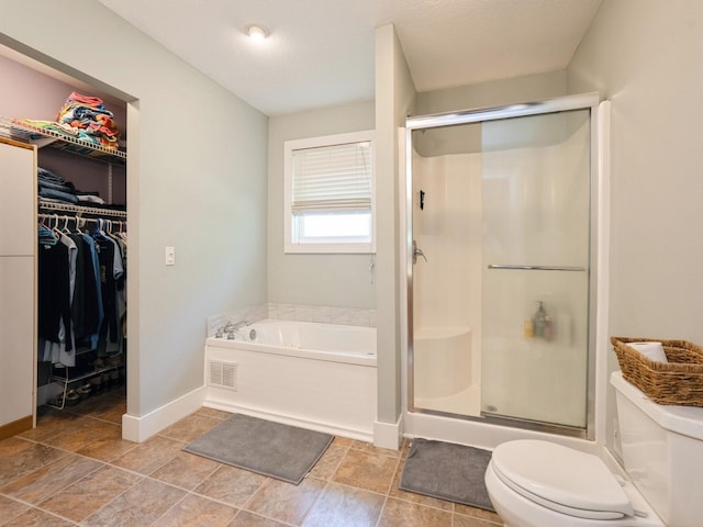 bathroom featuring toilet, a stall shower, baseboards, and a garden tub