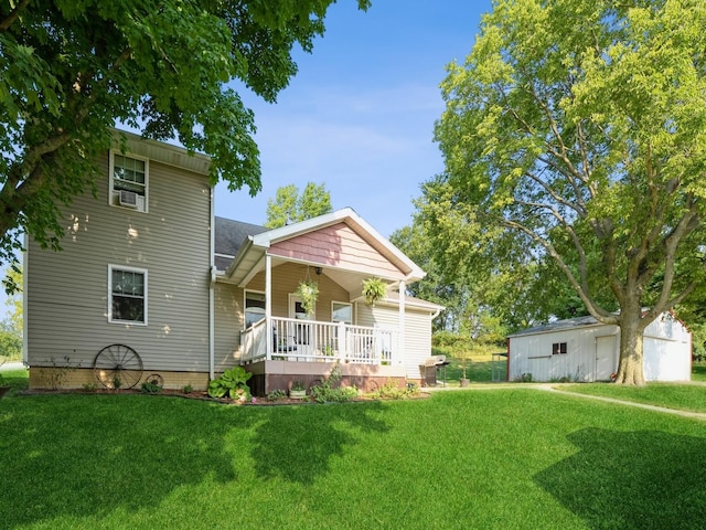 rear view of property with a porch, a lawn, and an outdoor structure