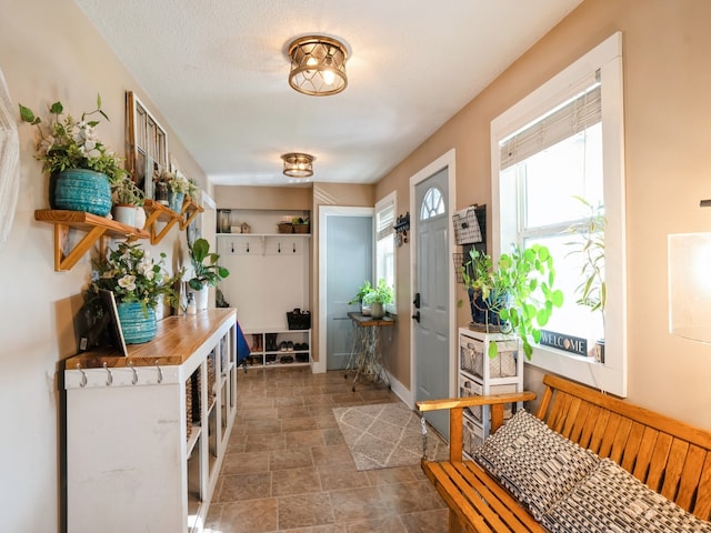 doorway to outside with a textured ceiling