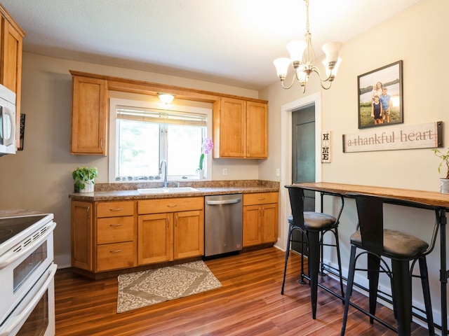 kitchen featuring white appliances, a sink, dark wood finished floors, and a notable chandelier