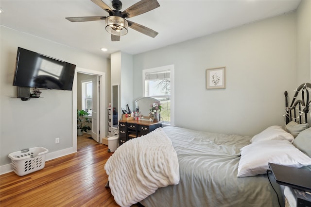 bedroom with a ceiling fan, baseboards, and hardwood / wood-style floors