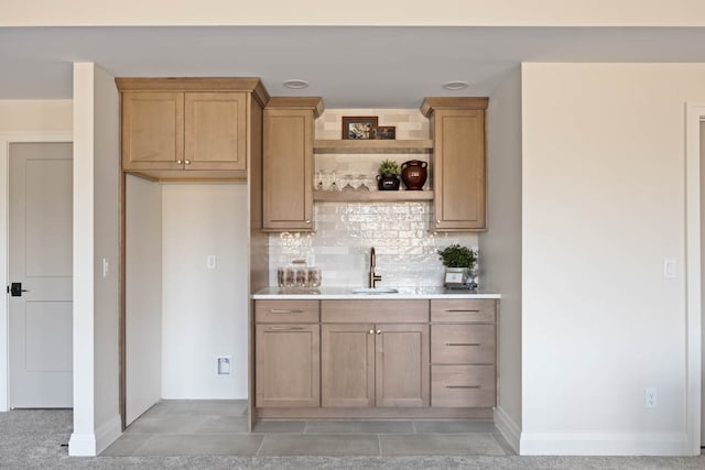 bar featuring decorative backsplash, light brown cabinets, tile patterned floors, and sink