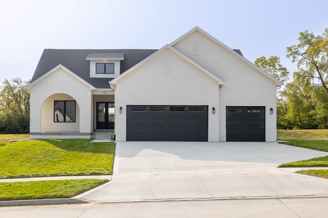 modern inspired farmhouse with french doors, a front lawn, and a garage