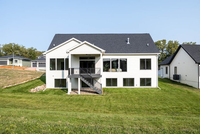 rear view of property featuring ceiling fan, a yard, a wooden deck, and central air condition unit