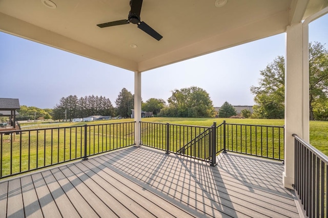 wooden deck featuring ceiling fan and a yard