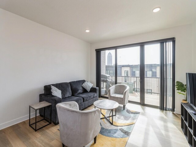 living room with recessed lighting, baseboards, and wood finished floors