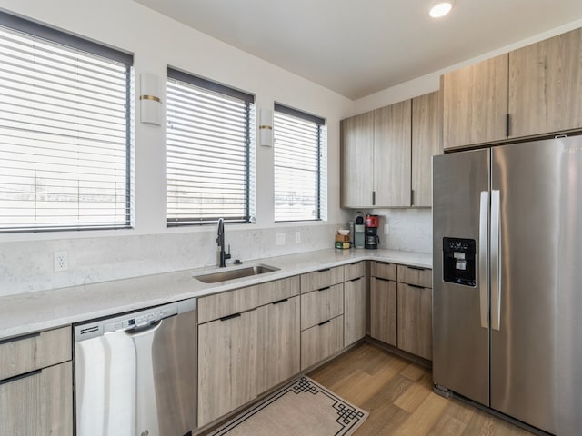 kitchen featuring light countertops, light brown cabinetry, appliances with stainless steel finishes, and a sink