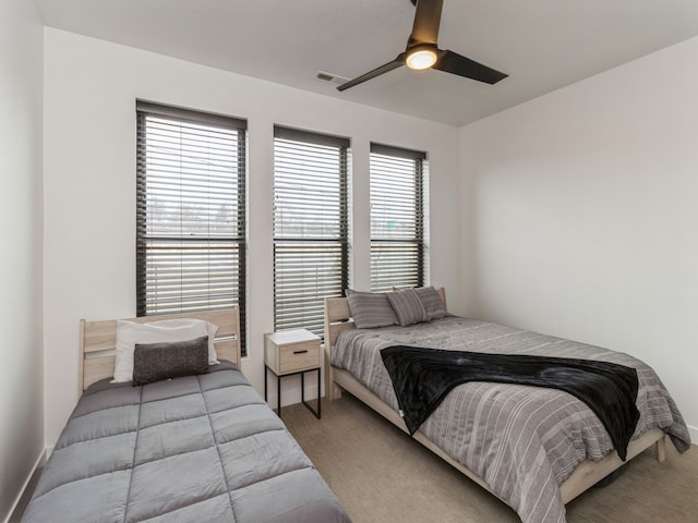 bedroom with visible vents, baseboards, carpet, and ceiling fan