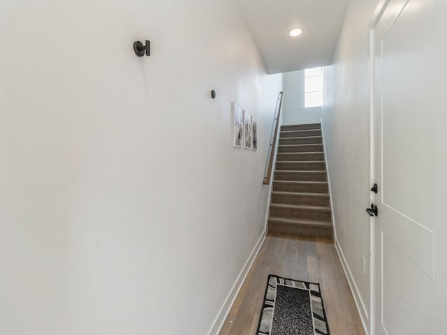 stairs featuring wood finished floors and baseboards