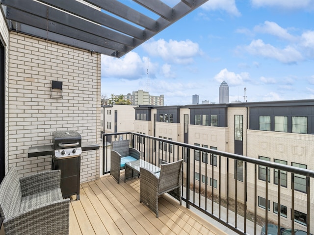 balcony with a city view, a pergola, and area for grilling