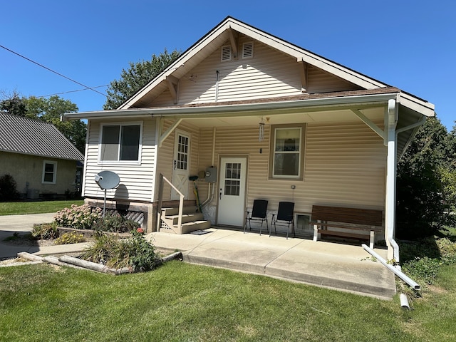 rear view of house featuring a yard and a patio