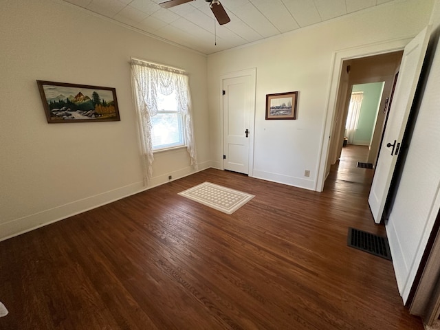 unfurnished bedroom with crown molding, dark wood-type flooring, and ceiling fan