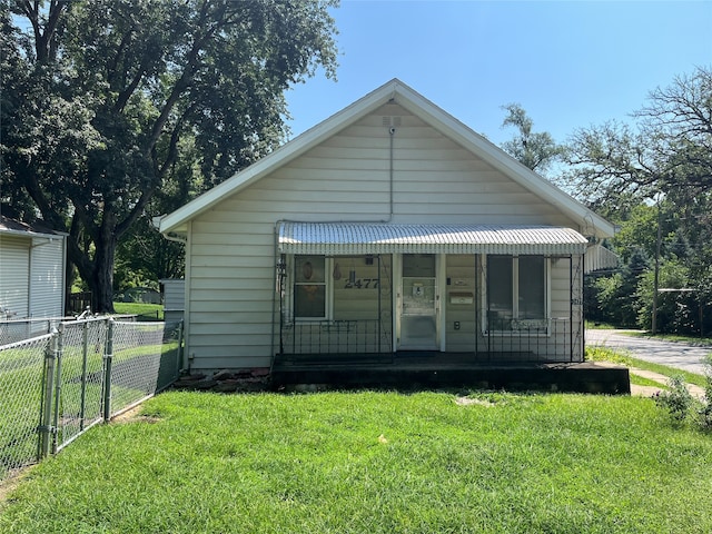 back of house featuring a yard and covered porch