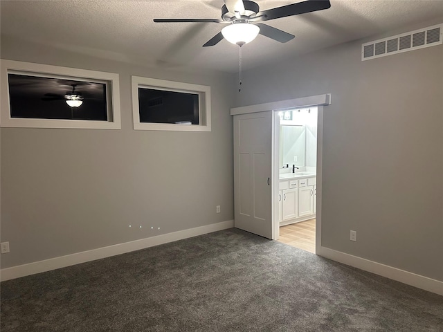 unfurnished bedroom with light carpet, ensuite bath, a textured ceiling, ceiling fan, and sink