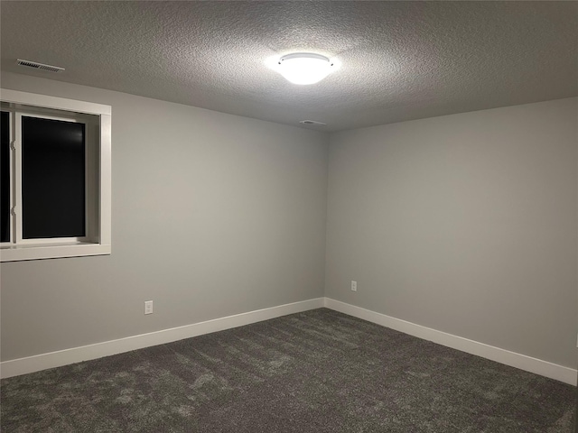 carpeted empty room featuring a textured ceiling