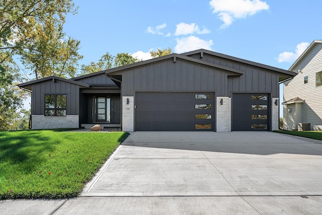 modern inspired farmhouse featuring a front yard and a garage