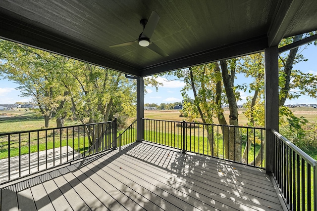 wooden terrace featuring ceiling fan, a rural view, and a yard