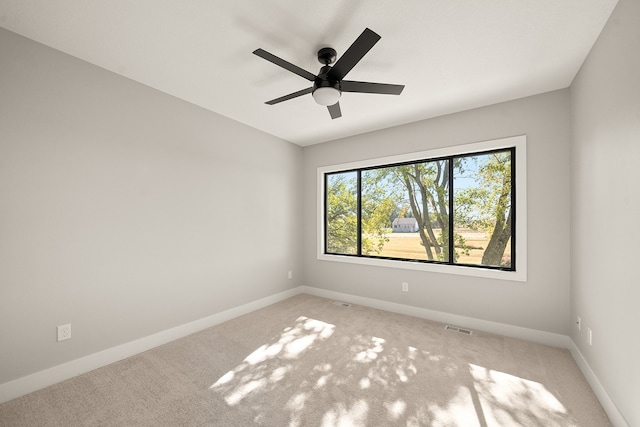 spare room with ceiling fan and light colored carpet