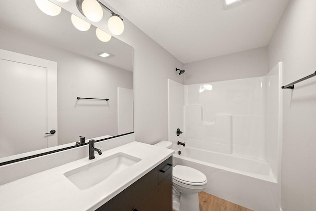bathroom with wood finished floors, vanity, tub / shower combination, toilet, and visible vents