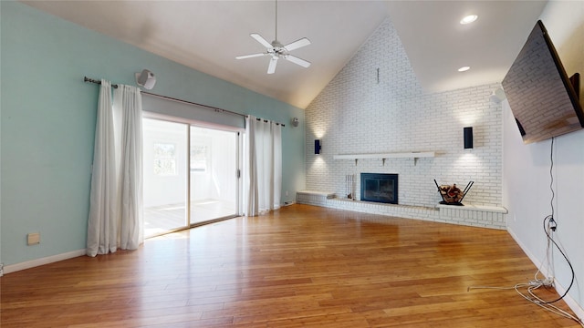 unfurnished living room with high vaulted ceiling, light wood-type flooring, a brick fireplace, and ceiling fan