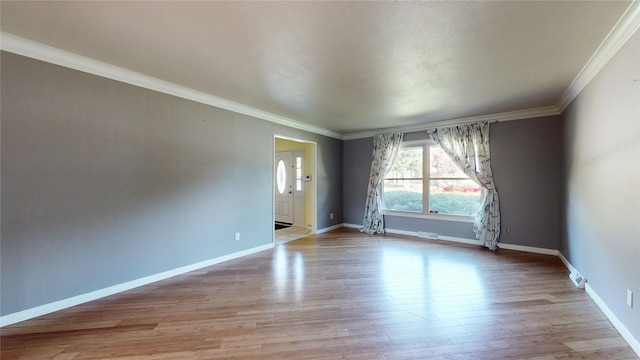 unfurnished room featuring baseboards, crown molding, and light wood finished floors