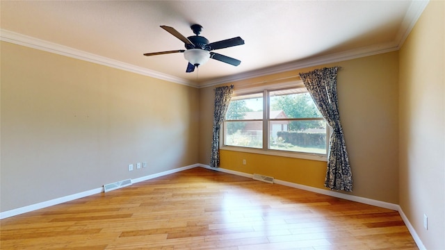 empty room featuring baseboards, light wood-style flooring, and crown molding