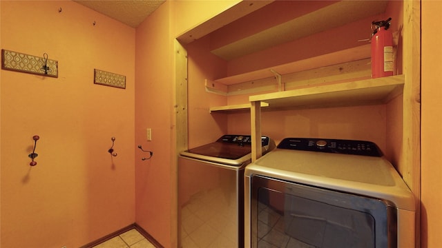 laundry area with laundry area, washing machine and dryer, and baseboards