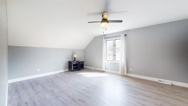 additional living space featuring baseboards, visible vents, lofted ceiling, ceiling fan, and wood finished floors