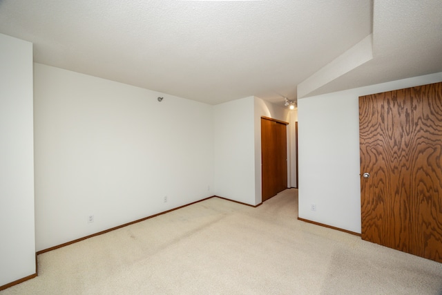 carpeted spare room featuring a textured ceiling