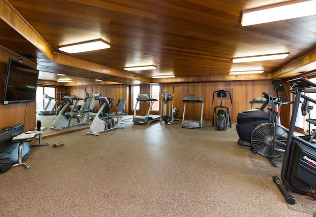 exercise room with wood ceiling and wood walls