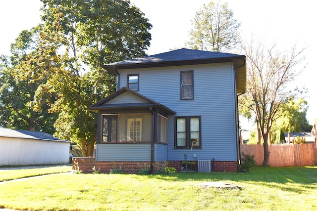 back of house with central AC unit, a lawn, fence, and a sunroom