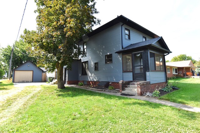 view of front of home featuring an outbuilding, a front yard, and a garage