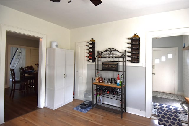 interior space featuring a ceiling fan, stairs, wood finished floors, and baseboards