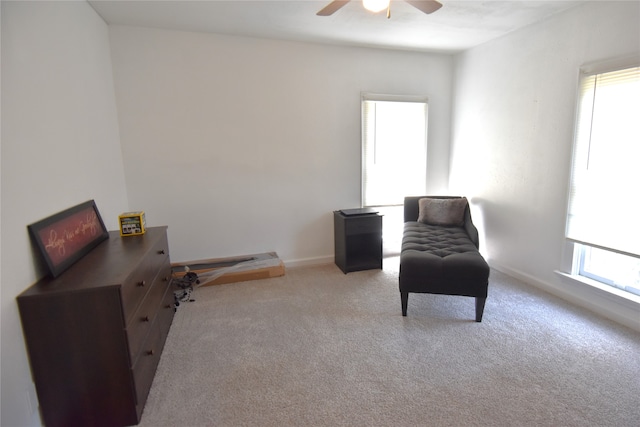 living area with carpet flooring, ceiling fan, and a wealth of natural light