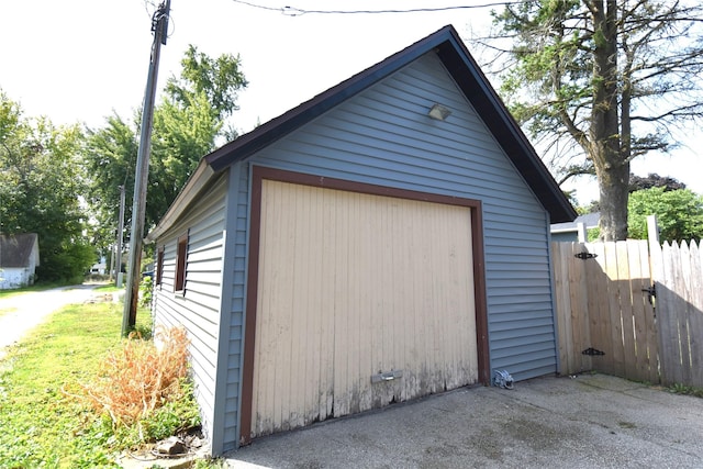 detached garage with driveway and fence