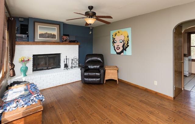 living room with ceiling fan, hardwood / wood-style floors, and a fireplace