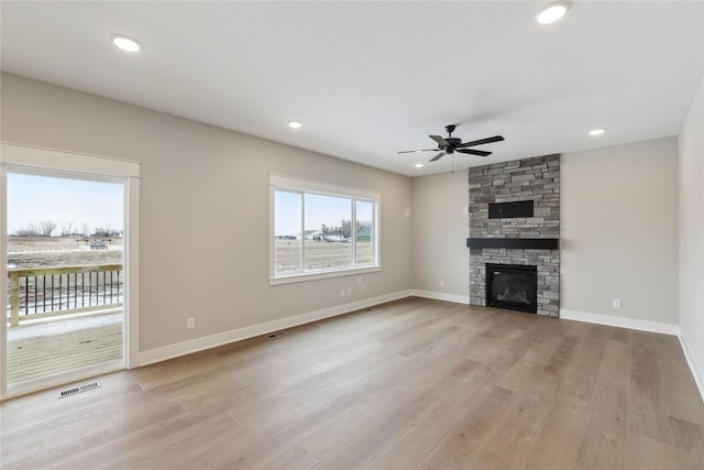 unfurnished living room featuring a fireplace, light hardwood / wood-style flooring, and ceiling fan