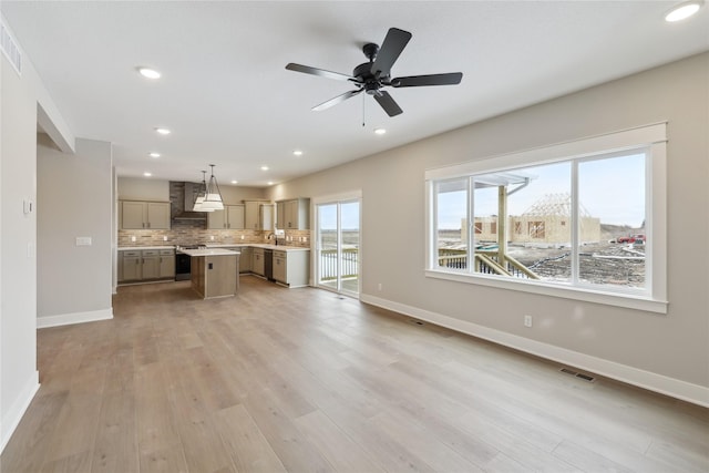 unfurnished living room featuring ceiling fan, light wood-type flooring, and sink