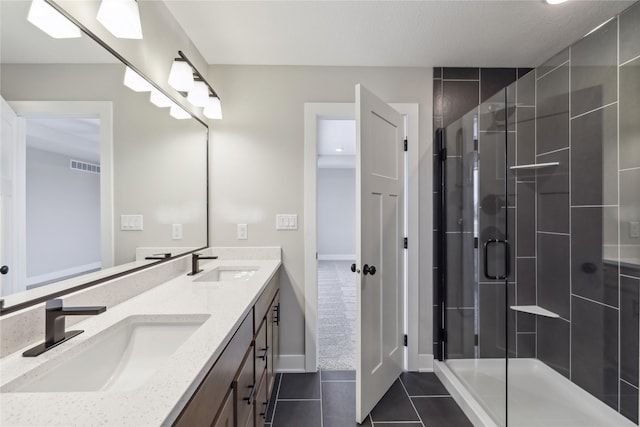 bathroom featuring tile patterned floors, vanity, and a shower with door