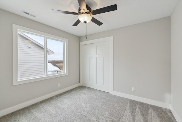 unfurnished bedroom featuring carpet, a closet, and ceiling fan