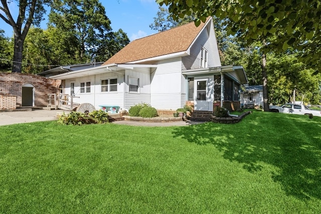 rear view of house featuring a lawn