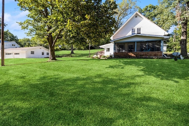 view of yard featuring a garage and a sunroom