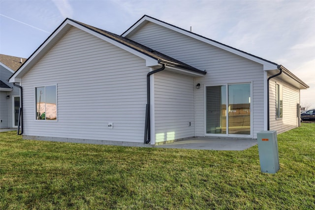 rear view of house featuring a yard and a patio