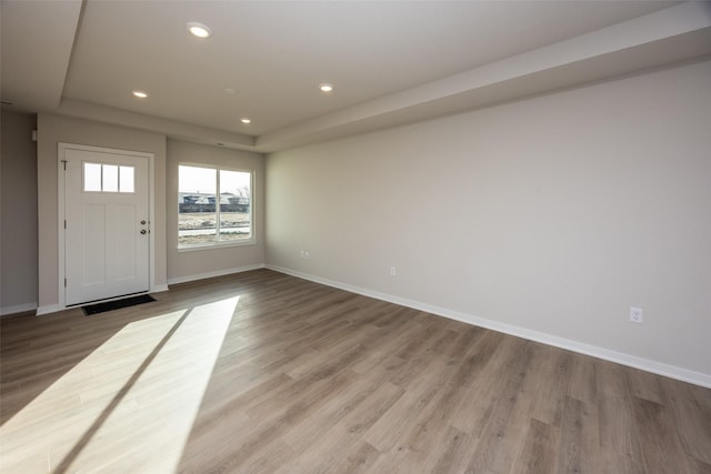 foyer featuring hardwood / wood-style flooring and a raised ceiling