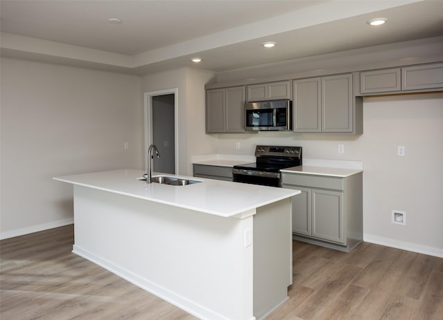 kitchen featuring gray cabinets, an island with sink, appliances with stainless steel finishes, and sink